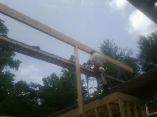 Carpenter setting a ridge beam over a new addition frame — Ice Dam Removal by Roofing Brothers in Nebo