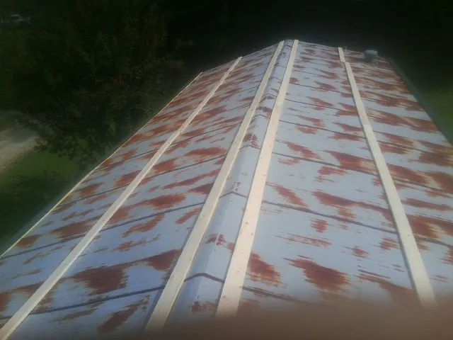 Rusted metal roof panels with new wood purlins before replacement — Storm Damage Roof Repair in Nebo by Roofing Brothers