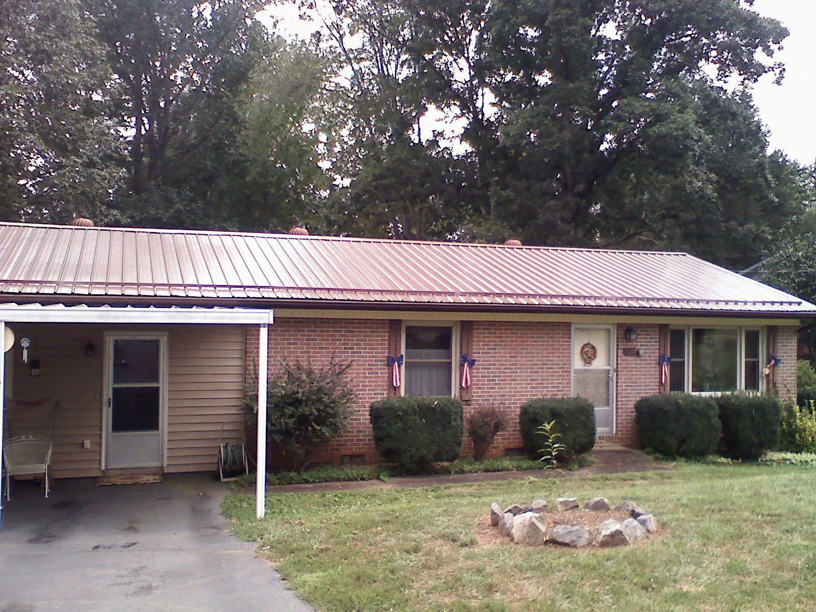 Bronze metal roof and carport on a brick ranch home — Roof Repair work by our crew in Nebo